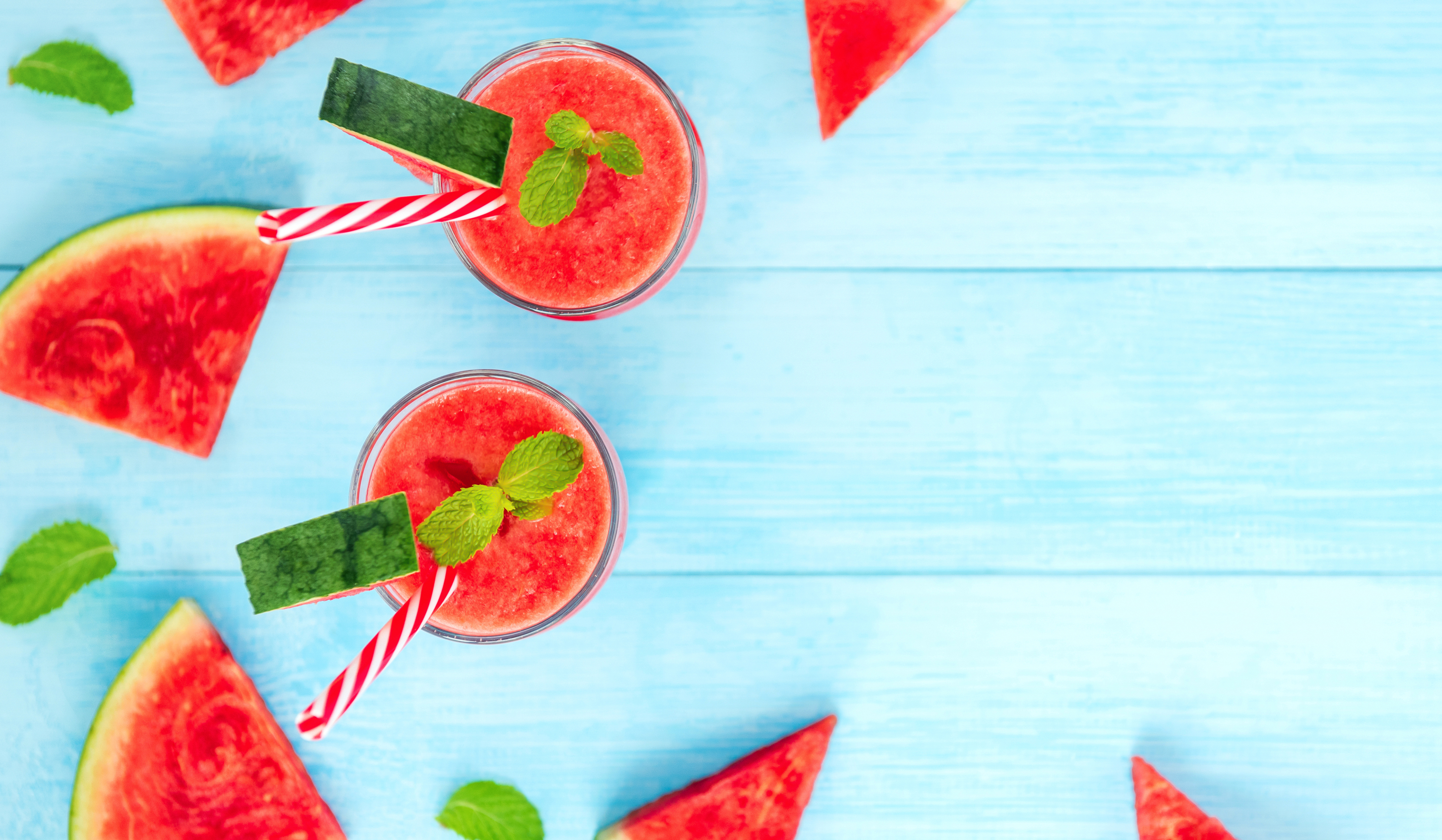 Melondrinkar och melonbitar på en blå bakgrund.